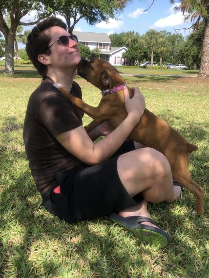 Teen playing with bulldog puppy