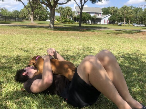 Teen playing with bulldog puppy