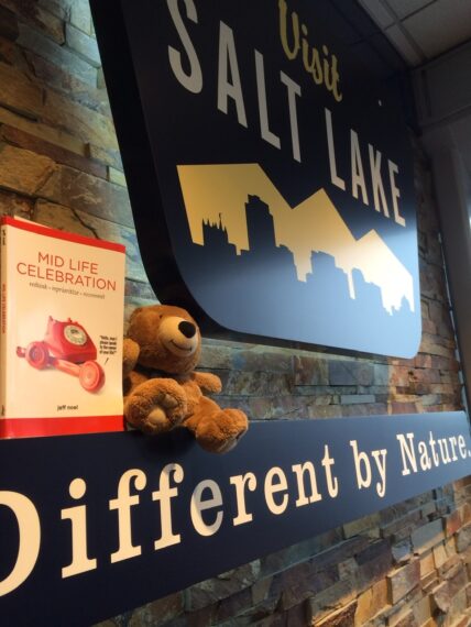 book and teddy bear at Salt Lake airport sign