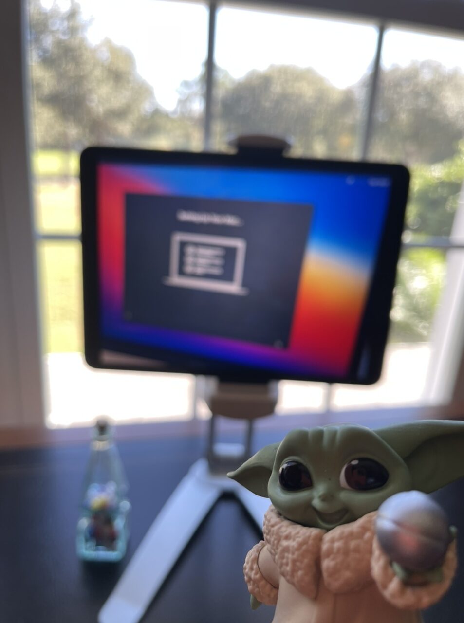 Baby Yoda toy and iPad at a desk