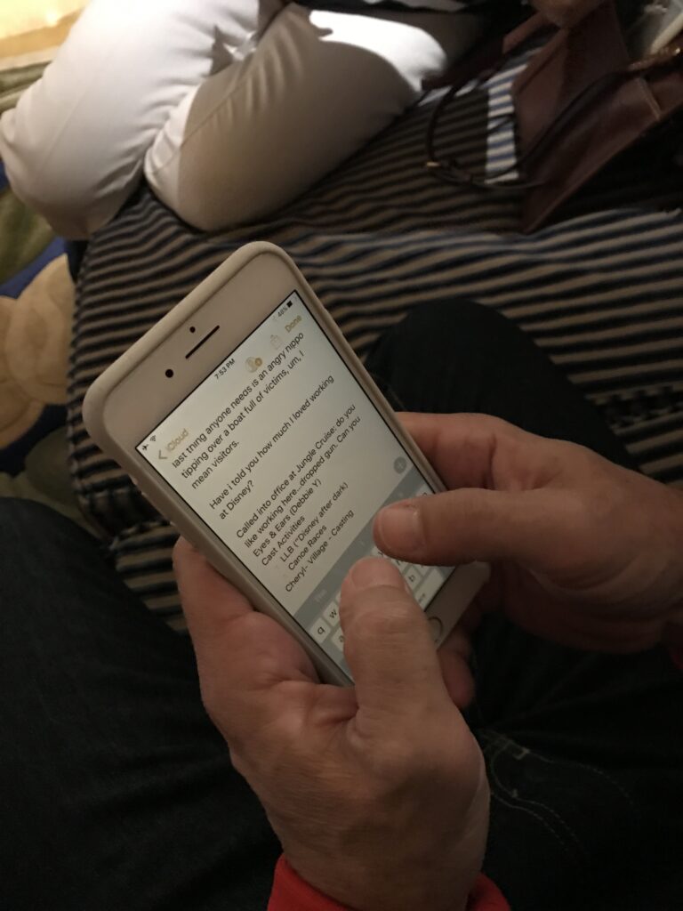 Disney business author Jeff Noel's hand while writing on an iPhone