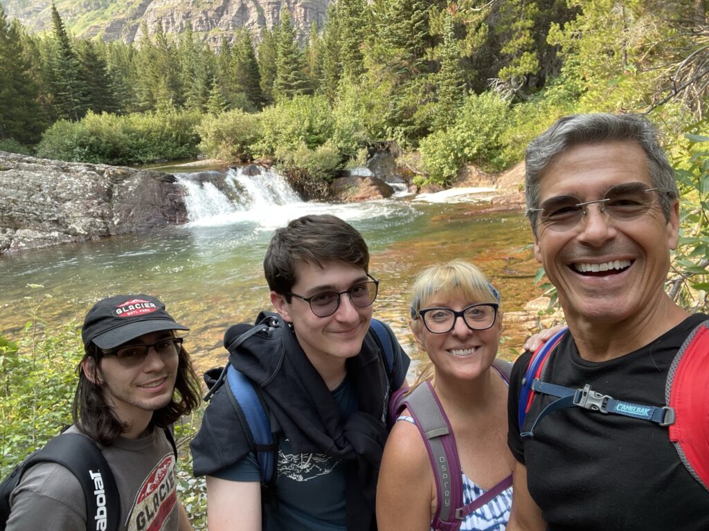 family of four hiking near small waterfall