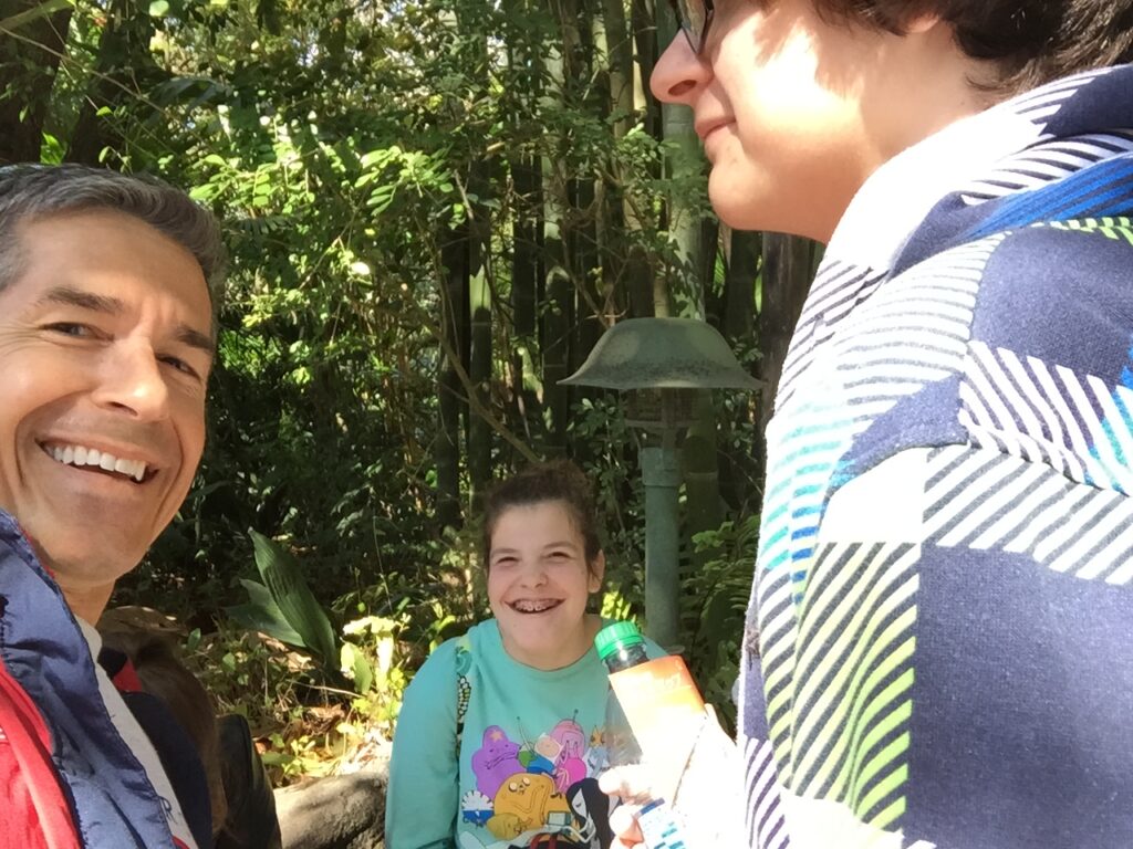 A dad with two middle schoolers smiling