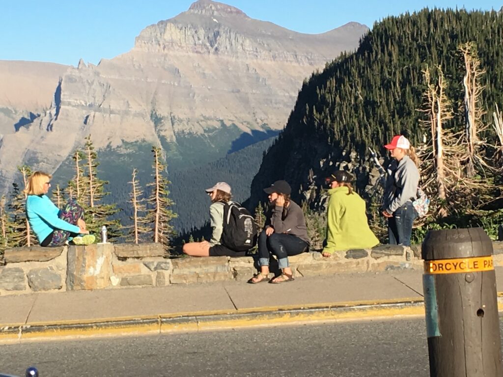 five people talking in the mountains