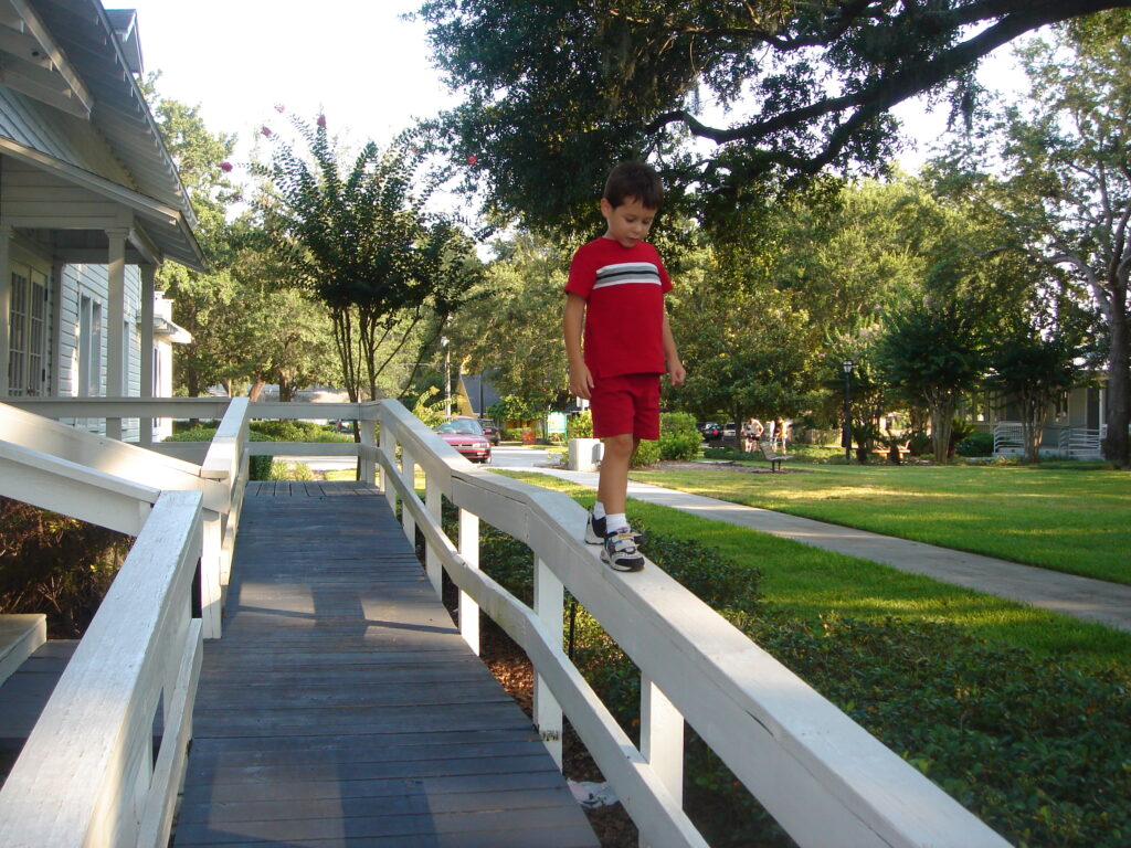 young boy walking on railing