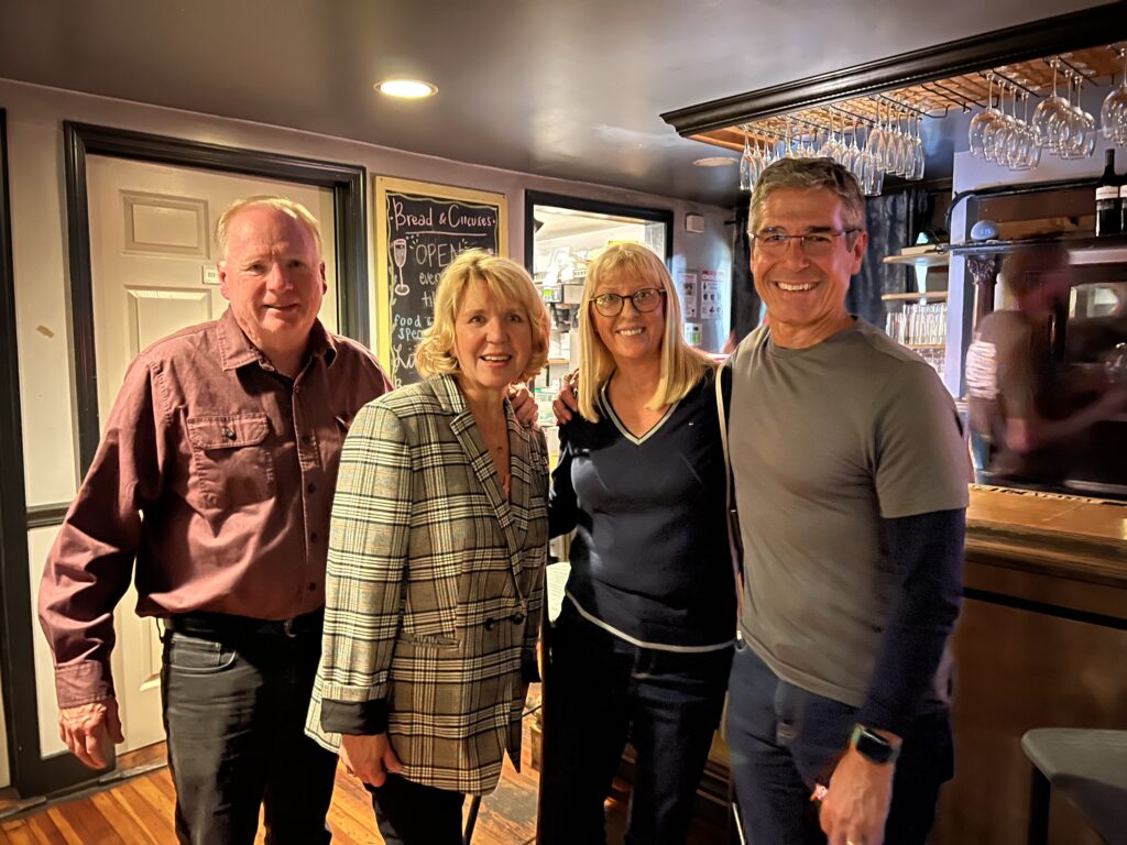 Four people posing in a bar